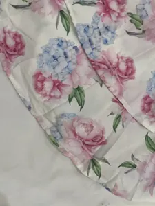 Detailed macro view of the elegant floral print fabric featuring pink and blue flowers
