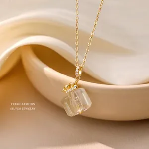 Primo piano dettagliato di una collana minimalista in argento s925 placcato oro con cubo
