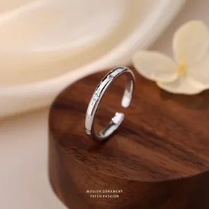 Vista dettagliata di un anello a stella minimalista in argento sterling S925 su legno