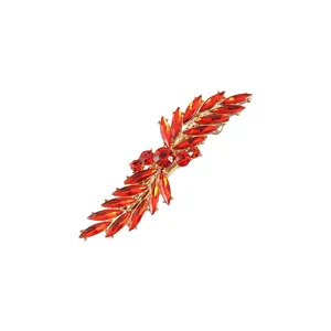 Detailed close-up of a sparkling red rhinestone leaf hair clip on white background