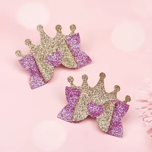 Nahaufnahme von handgefertigten Glitzerkronen und rosa Herz-Haarspangen für Kinder