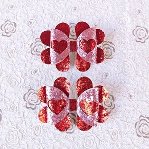 Detailansicht von roten und rosa Glitzer-Herzschleifen für Valentinstag-Haarspangen.