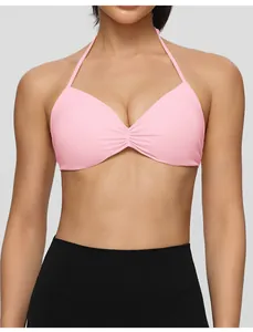 Close-up of pink halter neck sports bra showing fabric texture and ruched detail.