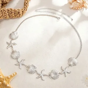 Detailed view of silver metal waist chain featuring textured starfish and shell charms