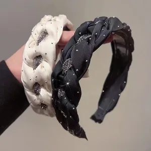 Detailed view of handmade braided headbands with sparkling rhinestones in black and cream.