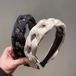 Close-up of handmade braided headbands with sparkling rhinestones in black and white.