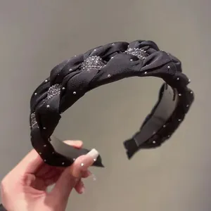 Elegant black braided headband detailed with sparkling rhinestones and fine pearls.
