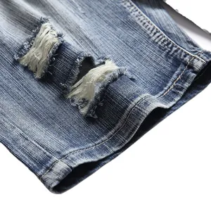 Detailed macro shot of distressed ripped texture on summer blue denim shorts for men