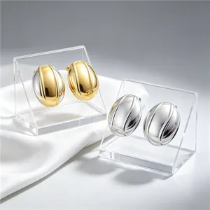 Détail des boucles d'oreilles ovales texturées en acier bicolore or et d'argent