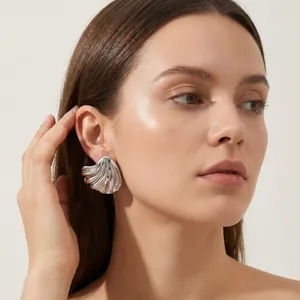 Detailed view of a model wearing irregular silver shell-shaped titanium steel earrings
