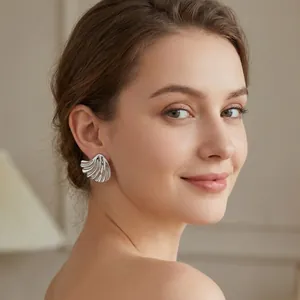 Detailed close-up of stylish irregular leaf-shaped titanium steel earrings on a model.