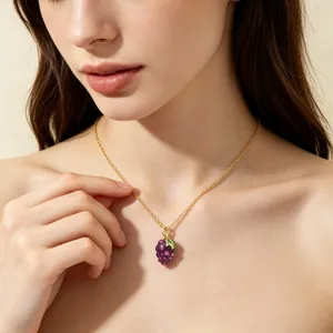 Detailed view of a gold stainless steel necklace with a purple grape fruit pendant