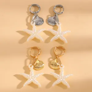 Vue détaillée macro de boucles d'oreilles d'été étoile de mer et coquillage or et argent