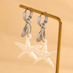Vue détaillée des boucles d'oreilles étoile de mer et coquillage, texture nacrée et argent