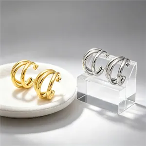 Elegant gold and silver triple hoop stainless steel earrings displayed on stands