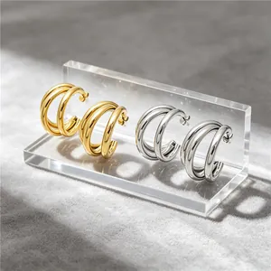 Macro view of minimalist stainless steel triple hoop earrings in gold and silver