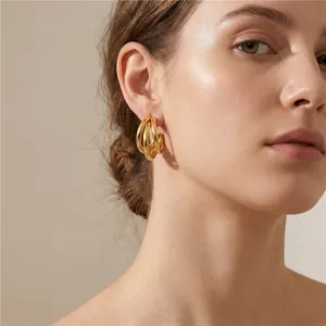Close-up of elegant golden triple-layered stainless steel C-shaped hoop earrings