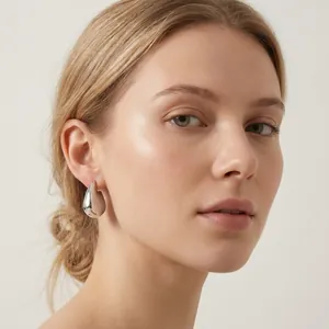 Détail d'un mannequin portant une boucle d'oreille irrégulière en forme de nageoire.