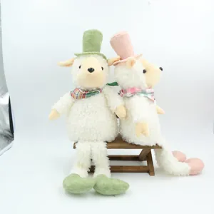 Detail view of two vintage sheep plush toys with colorful top hats on a mini bench