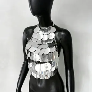 Dettaglio di un elegante top a lupetto con paillettes argento e dischi metallici