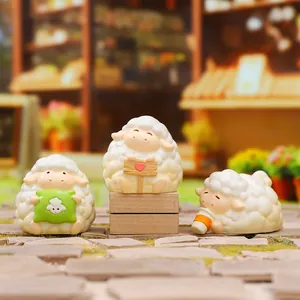 Trois figurines de moutons mignons dans diverses poses dans une scène de rue miniature
