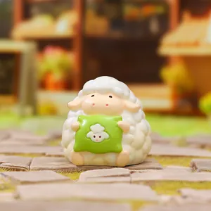 Détail rapproché d'une figurine de mouton Meimei Lam tenant un oreiller vert.