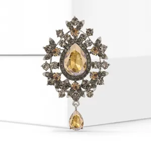 Close-up detail of a vintage amber glass teardrop brooch with silver accents