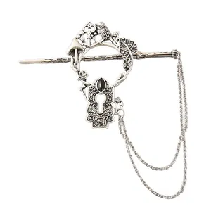 Detailed view of a vintage silver alloy hair stick with bird and keyhole motifs.