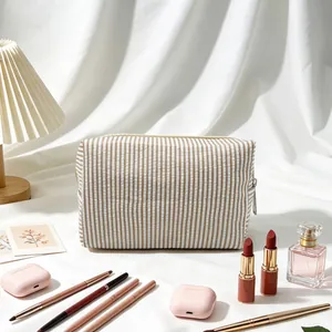Große gestreifte Seersucker-Kosmetiktasche für Make-up-Aufbewahrung auf dem Tisch