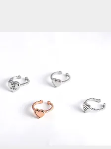 Detailed view of four stainless steel heart rings with engraved inspirational quotes