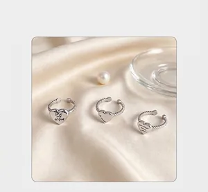 Close-up detail of three stainless steel heart rings with inspirational text engravings