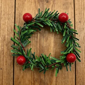 Feestelijke kerstkrans met groene dennennaalden en rode bessen op houten achtergrond