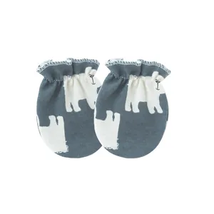 Close-up detail of newborn baby anti-scratch mittens featuring a cute white polar bear print