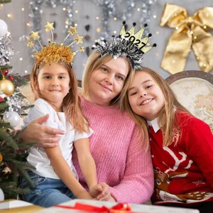 Family wearing 2027 New Year headbands with stars and crowns at a festive party.