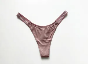 Macro view of sexy ice silk T-back thong with shimmer texture and elastic straps.