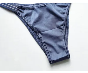 Detailed close-up of blue ice silk thong showing fine stitching and shiny satin texture