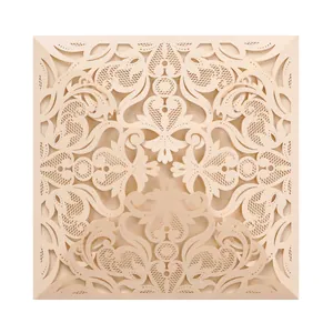 Detailed close-up of intricate laser-cut floral lace pattern on beige invitation cover