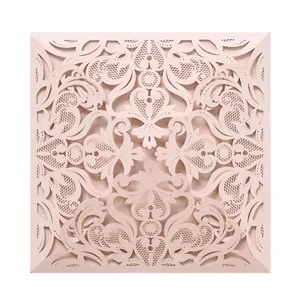 Intricate laser-cut lace wedding invitation cover in elegant blush pink floral design