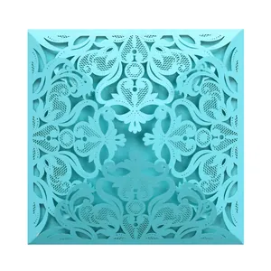 Intricate laser-cut heart and floral lace pattern on a cyan invitation cover