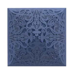 Detail of intricate laser-cut lace pattern on navy blue wedding invitation cover