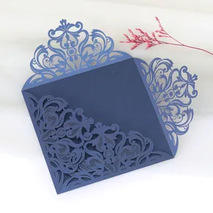 Intricate laser-cut lace pattern on navy blue wedding invitation cover shown in detail