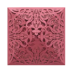 Detailed view of intricate laser-cut lace pattern on burgundy invitation cover