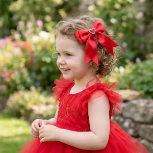 Red heart bow hair clip on young girl in garden setting