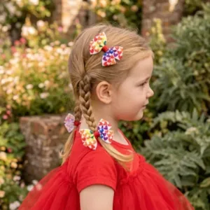 Charming young girl wearing colorful heart patterned bow hair clips in braided hair