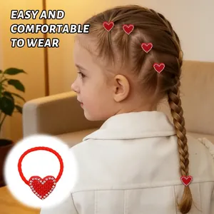 Detail of red rhinestone heart hair ties worn on a child's braided hairstyle.