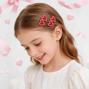 Detail of cute red glitter heart hair clips worn by a young girl for Valentine's Day.