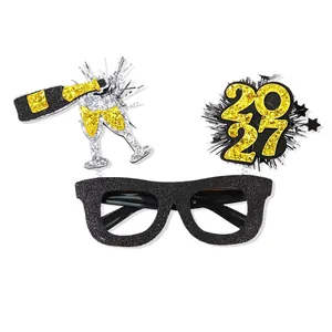 Glittery 2027 New Year party glasses frame with champagne decorations for festive photos.