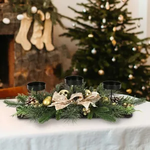 Detailed view of a Christmas three-cup candle holder with pine needles and golden bow.