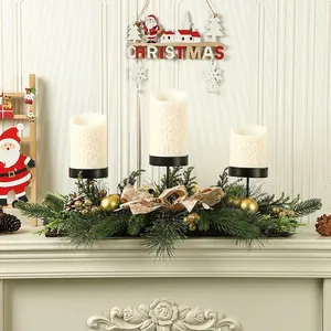 Detailed view of a Christmas 3-candle centerpiece with greenery and gold baubles.