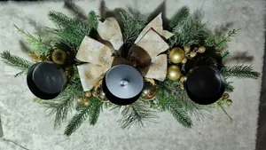 Overhead detail of a Christmas candle holder with golden ornaments and bows
